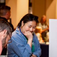 two attendees examine a student poster at student project showcase